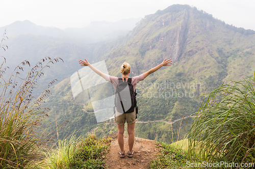 Image of Active caucasian blonde woman enjoing fresh air and pristine nature while tracking among tea plantaitons near Ella, Sri Lanka. Bacpecking outdoors tourist adventure