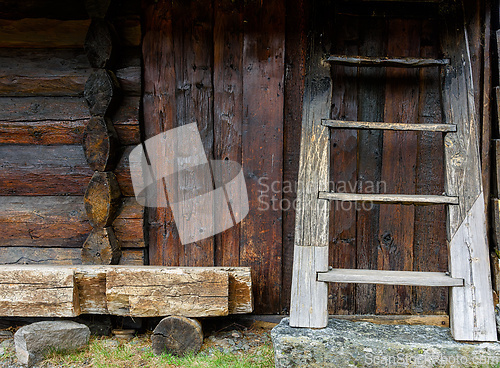 Image of Rustic wooden cabin features a ladder and textured walls in a se