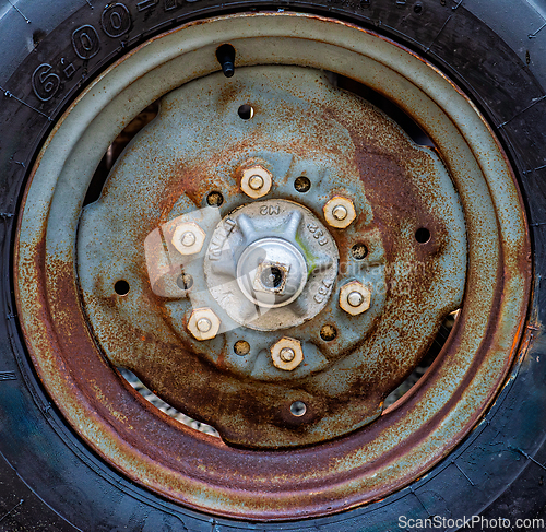Image of Rusty wheel rim close-up showing bolts and texture from wear in 