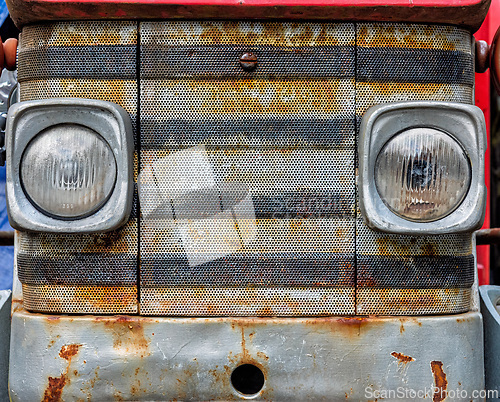 Image of Rusty tractor front with distinctive grill and headlights captur
