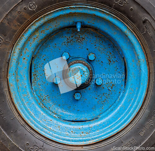 Image of Colorful blue wheel on a rugged surface showcasing weathered det