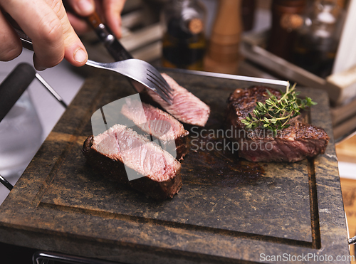 Image of Chef cutting grilled medium rare steak