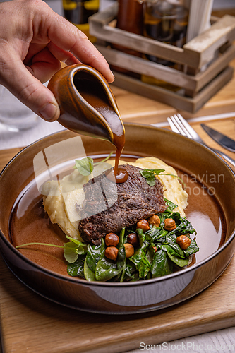 Image of Chef pouring gravy on roasted beef