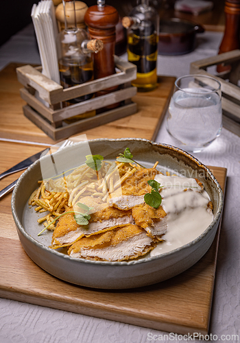 Image of Breaded chicken breast with white sauce