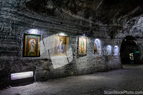 Image of Religious artwork and statues on the textured stone walls of the Salt Cathedral of Zipaquira, Colombia.