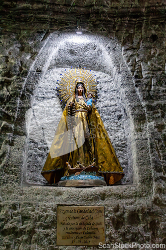 Image of Religious artwork and statues on the textured stone walls of the Salt Cathedral of Zipaquira, Colombia.