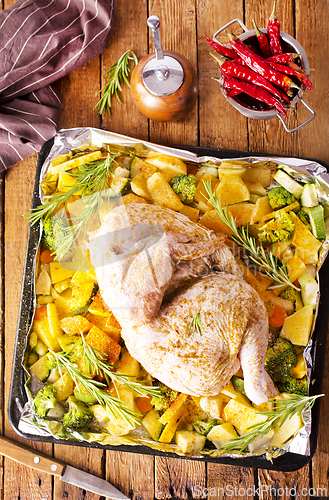 Image of Uncooked chicken with parsley and potatoes