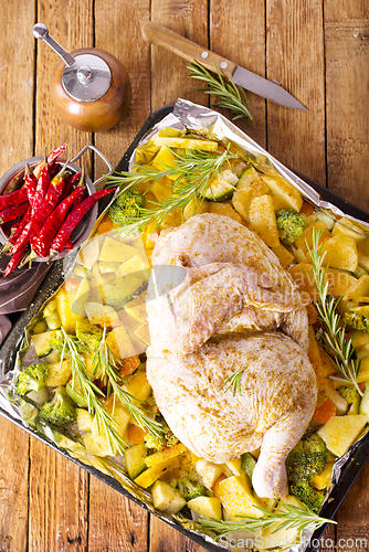 Image of Uncooked chicken with parsley and potatoes