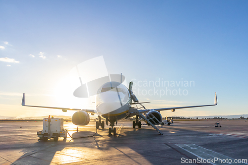Image of Commercial passengers airplane on airport runway in sunset