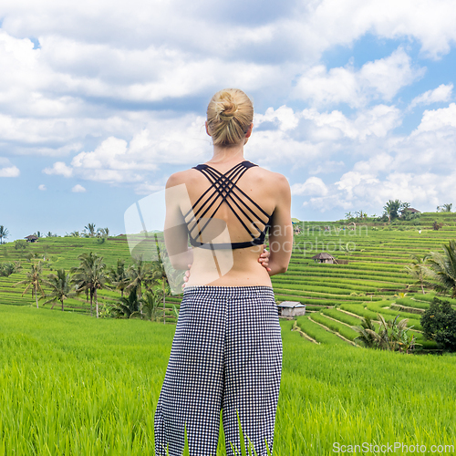Image of Relaxed casual sporty woman enjoying pure nature at beautiful green rice fields on Bali.