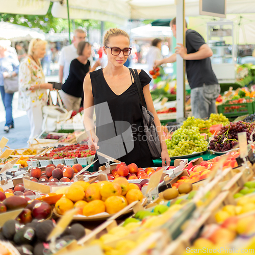 Image of Woman buying fruits and vegetables at local food market. Market stall with variety of organic vegetable