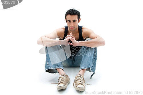 Image of Handsome guy sitting on floor