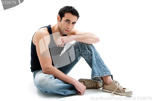 Image of Handsome guy sitting on floor