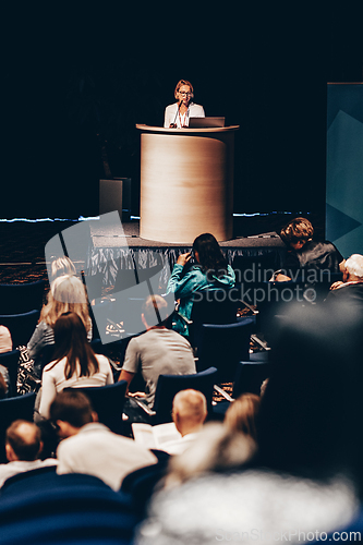 Image of Female speaker giving a talk on corporate business conference. Unrecognizable people in audience at conference hall. Business and Entrepreneurship event.
