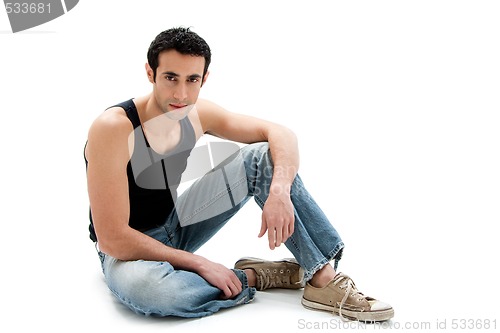 Image of Handsome guy sitting on floor