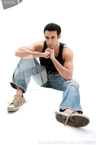 Image of Handsome guy sitting on floor
