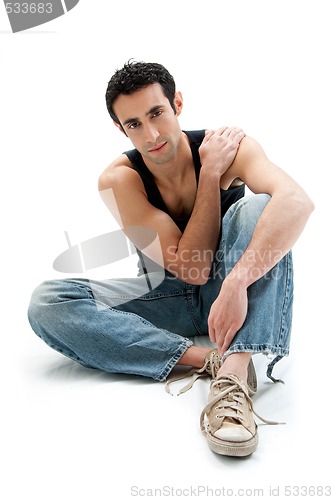 Image of Handsome guy sitting on floor