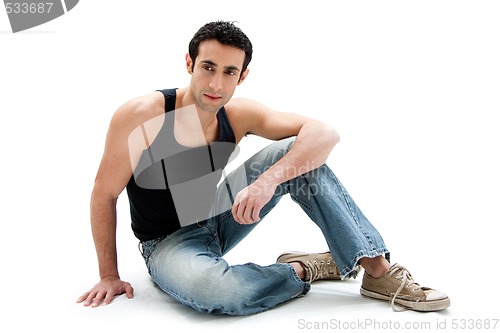 Image of Handsome guy sitting on floor