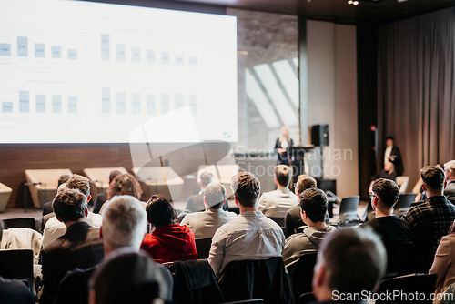 Image of Female speaker giving a talk on corporate business conference. Unrecognizable people in audience at conference hall. Business and Entrepreneurship event.