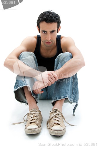 Image of Handsome guy sitting on floor