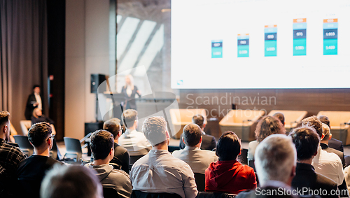 Image of Female speaker giving a talk on corporate business conference. Unrecognizable people in audience at conference hall. Business and Entrepreneurship event.