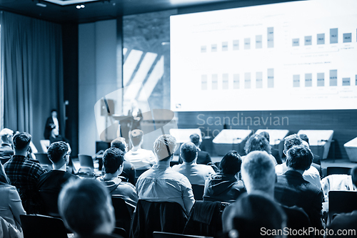 Image of Speaker giving a talk in conference hall at business event. Business and entrepreneurship concept. Blue toned black and white image.