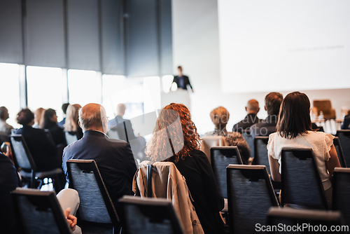 Image of Speaker giving a talk in conference hall at business event. Rear view of unrecognizable people in audience at the conference hall. Business and entrepreneurship concept.