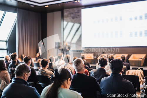 Image of Female speaker giving a talk on corporate business conference. Unrecognizable people in audience at conference hall. Business and Entrepreneurship event.