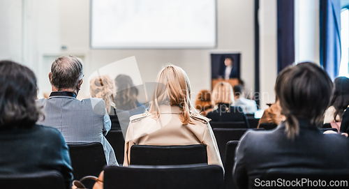Image of Speaker giving a talk in conference hall at business event. Rear view of unrecognizable people in audience at the conference hall. Business and entrepreneurship concept.