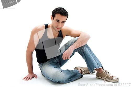 Image of Handsome guy sitting on floor