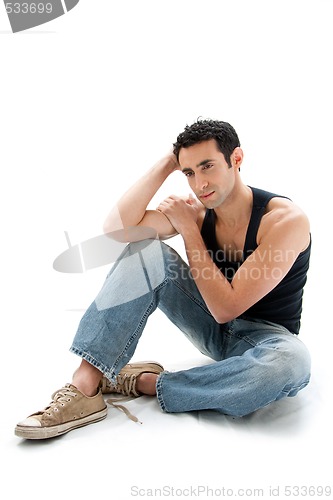 Image of Handsome guy sitting on floor