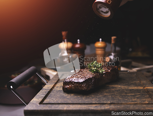 Image of Chef adding salt and thyme to grilled steak