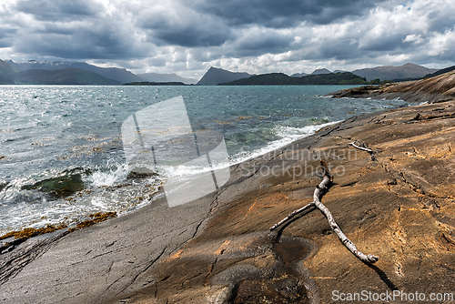 Image of Coastal landscape with rocky shoreline under dramatic sky near t
