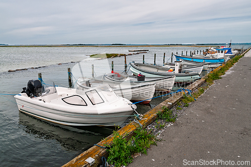 Image of Boats docked along a calm waterway in a serene coastal setting d