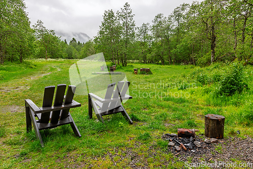Image of Relaxing outdoor seating area in a lush forest during a cloudy d