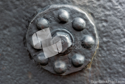 Image of Close-up view of a textured metal bolt on an industrial surface 