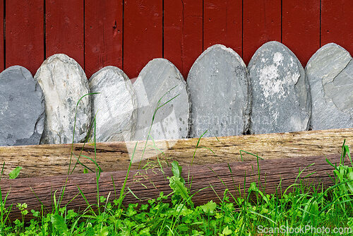 Image of Decorative stone arrangement along a rustic wooden fence in a gr