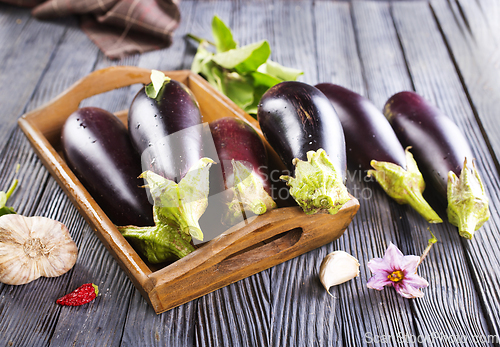 Image of Raw eggplants ( aubergines ) in wooden box. Selective focus
