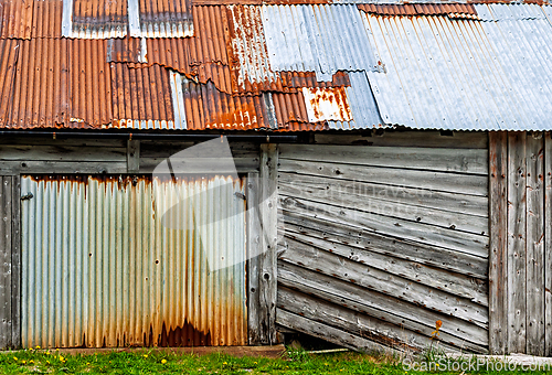 Image of Rustic barn exterior with weathered corrugated metal roofing in 