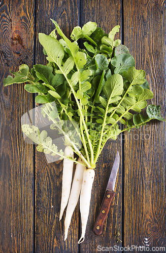 Image of White radish and knife on wooden board
