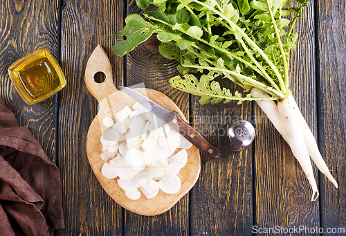 Image of White radish and knife on wooden board