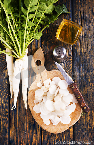 Image of White radish and knife on wooden board