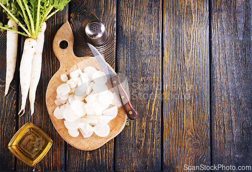 Image of White radish and knife on wooden board
