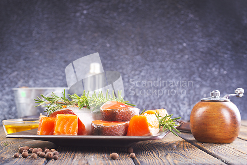 Image of Salmon. Fresh raw salmon fish fillet with cooking ingredients, herbs and lemon on dark background