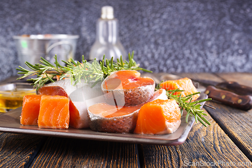 Image of Salmon. Fresh raw salmon fish fillet with cooking ingredients, herbs and lemon on dark background