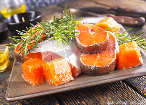 Image of Salmon. Fresh raw salmon fish fillet with cooking ingredients, herbs and lemon on dark background