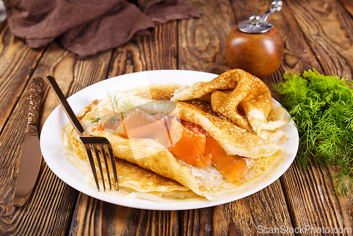 Image of Pancakes with salmon (trout). Thin, not sweet blinchiki stuffed with red fish.