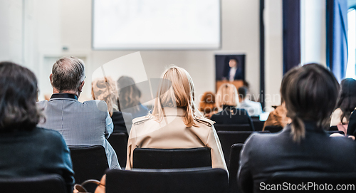 Image of Speaker giving a talk in conference hall at business event. Rear view of unrecognizable people in audience at the conference hall. Business and entrepreneurship concept.