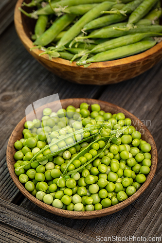 Image of Fresh green peas in wooden bowls