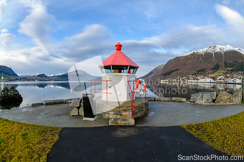 Image of Scenic lighthouse overlooking calm waters in a serene mountain l